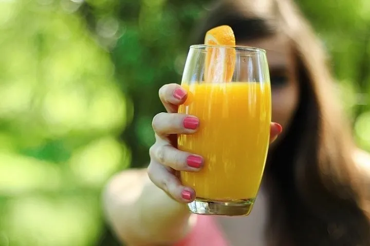 オレンジジュースを持つ女性
